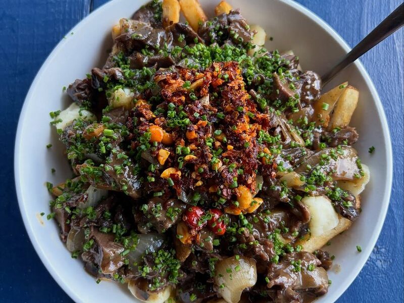Beef cheek poutine with cheddar curds, gravy, chili crisp and chives